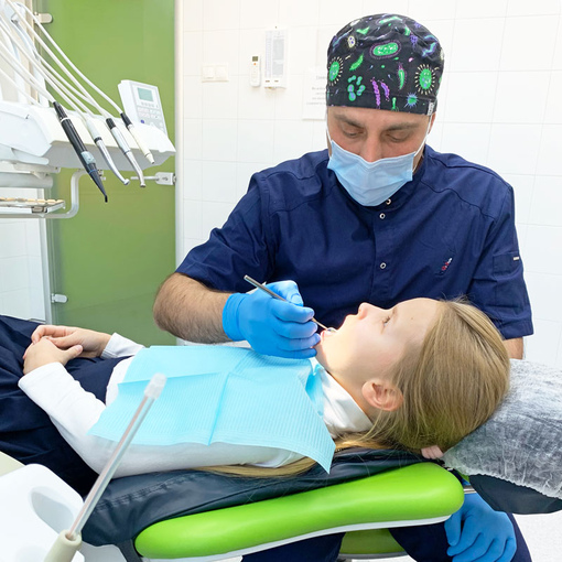 Врач-стоматолог Комаров Олег Васильевич проводит осмотр пациента