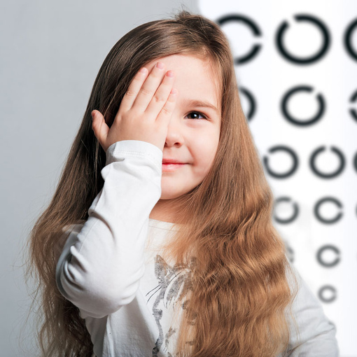 Девушка на фоне таблицы для оценки остроты зрения